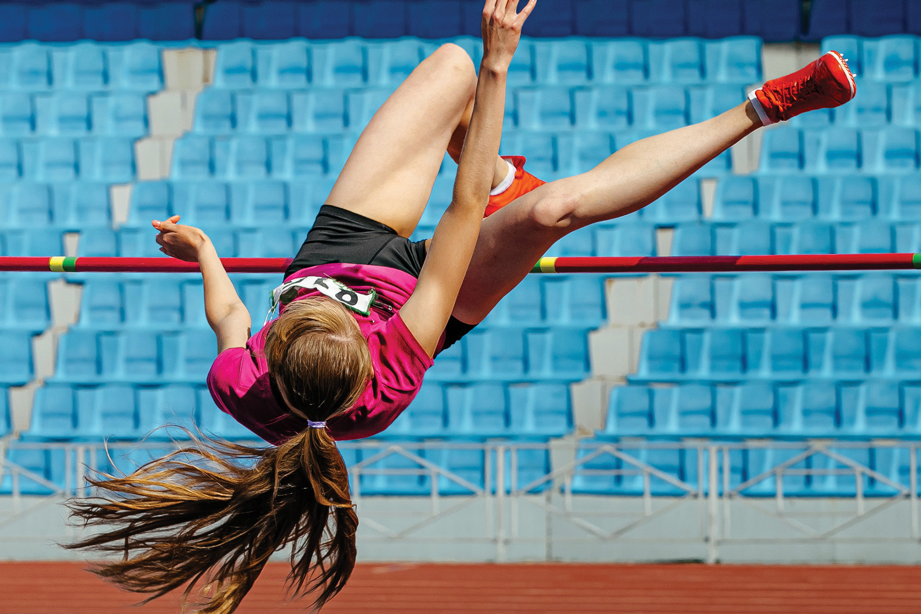 En flicka som hoppar över en ribba i höjdhopp.